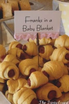 there is a plate full of pigs in a blanket on display at the baby shower