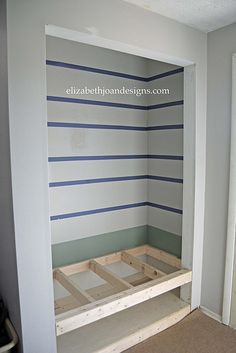 an empty room with blue and white striped walls