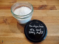 a jar of sugar next to a glass container with some writing on it