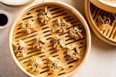 some dumplings are sitting in a bamboo steamer on a table next to a cup and saucer