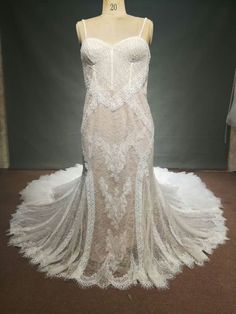 a white wedding dress on display in front of a mannequin's head