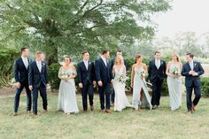 a group of people standing next to each other on top of a grass covered field