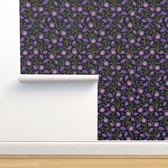 purple and green flowers on black wallpaper in an empty room