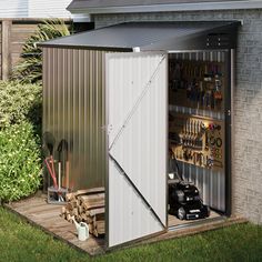 an outdoor storage shed with its doors open and tools in the back ground next to it