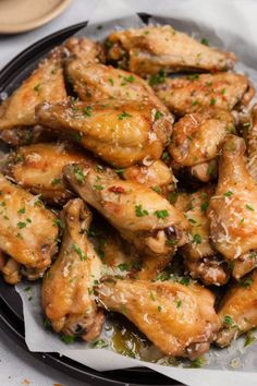 a plate full of chicken wings covered in gravy