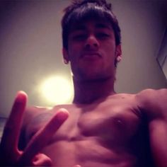 a shirtless man making the peace sign with his fingers