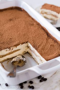 there is a cake in the pan with chocolate and cream toppings on it, ready to be eaten