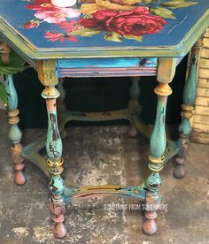 a blue table with flowers painted on it