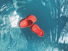 two red shoes floating on top of blue water