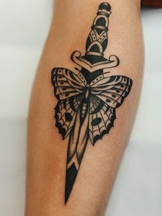 a black and white tattoo on the leg of a woman with a knife in it