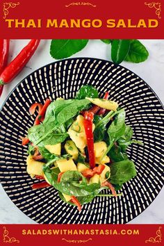 thai mango salad on a black and white plate with red chili peppers in the background