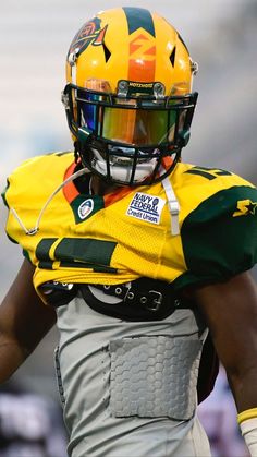 a football player wearing a yellow and green uniform