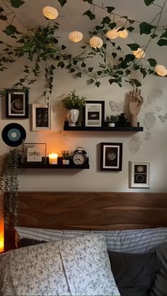 there are many pictures on the wall above the bed and candles in front of them