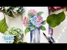 an arrangement of flowers and greenery is displayed on a white surface with watercolor markers