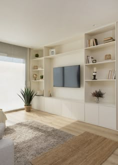 a living room with bookshelves and a flat screen tv mounted on the wall