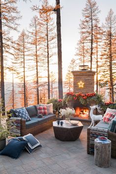 an outdoor patio with wicker furniture, fireplace and christmas decorations on the table in front of it