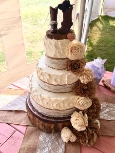 a wedding cake with flowers and cowboy boots on top