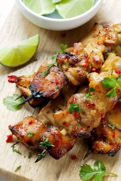 chicken skewers with cilantro and lime on a cutting board