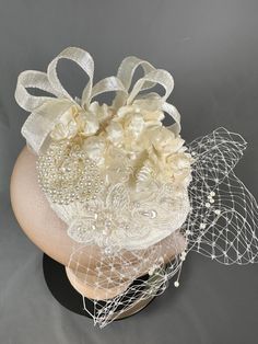 Cute mini cream bridal fascinator.  Adorned with tiny roses. Appliqués, pearl brooch, ribbon and veiling.  Attached with large clip Elegant Cream Party Veil, Elegant Cream Fascinator For Vintage Events, Elegant Cream Headpieces For Wedding, Elegant Cream Wedding Headpiece, Elegant Wedding Headpiece With Flower Decoration, Elegant Floral Wedding Headpieces, Elegant Handmade Flower Hair Accessories For Formal Events, Elegant Handmade Flower Hair Accessories For Formal Occasions, Elegant Flower Hair Accessories For Wedding