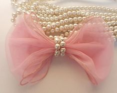 a close up of pearls and a bow on a necklace