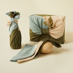 two vases, one with flowers and the other with fabric wrapped around it