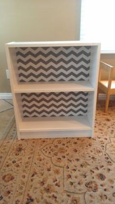 a white book shelf sitting on top of a carpeted floor