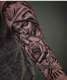 a man with a cross and rose tattoo on his arm