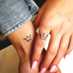 two people with matching tattoos on their hands, one has a crown tattoo on the other