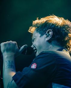 a man with red hair singing into a microphone