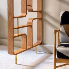 a chair sitting in front of a book shelf next to a white carpeted floor