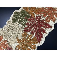 three different colored leaves on a white doily with red, green and orange colors