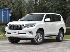 a white toyota land cruiser parked in front of some trees