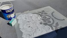 a can of paint sitting on top of a table next to a stencil