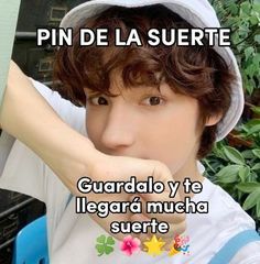 a young man wearing a white hat and holding his hand up to his face with the words pin de la suerte on it