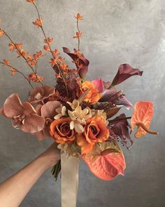 a bouquet of flowers is being held by someone's hand