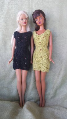 two dolls are posed next to each other