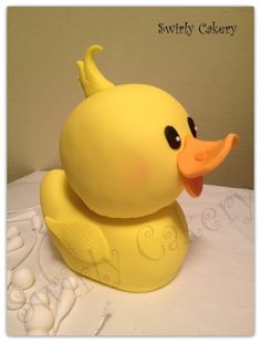 a yellow rubber ducky sitting on top of a white table covered in icing