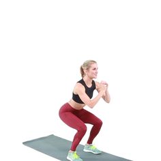 a woman standing on a yoga mat with her hands together