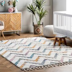 a baby's room with a crib, chair and rug