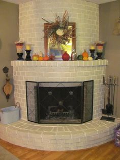 a living room with a fire place next to a mirror and vases on the mantle