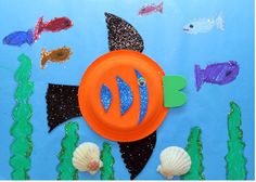 an orange frisbee sitting on top of a blue surface with fish and seaweed