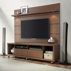 a flat screen tv sitting on top of a wooden entertainment center next to a vase