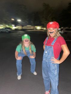 two girls in overalls and red caps posing for the camera