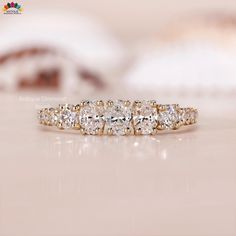 a three stone diamond ring sitting on top of a table