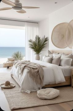 a bedroom with a large bed next to a window overlooking the ocean and palm trees