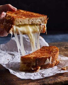 a grilled cheese sandwich is being held up