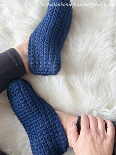 a woman's feet wearing blue crocheted slippers