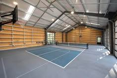 an indoor tennis court with a basketball hoop