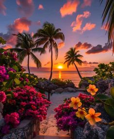 the sun is setting over the ocean with palm trees and flowers in front of it