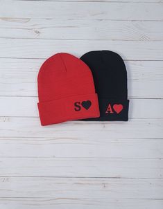 two beanies with hearts on them are sitting next to each other against a white background